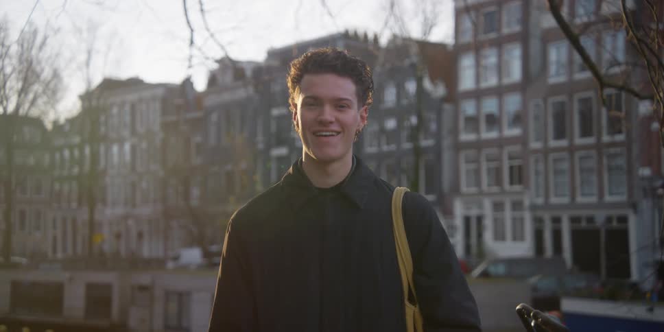 Portrait of a young man smiling in the middle of an urban city