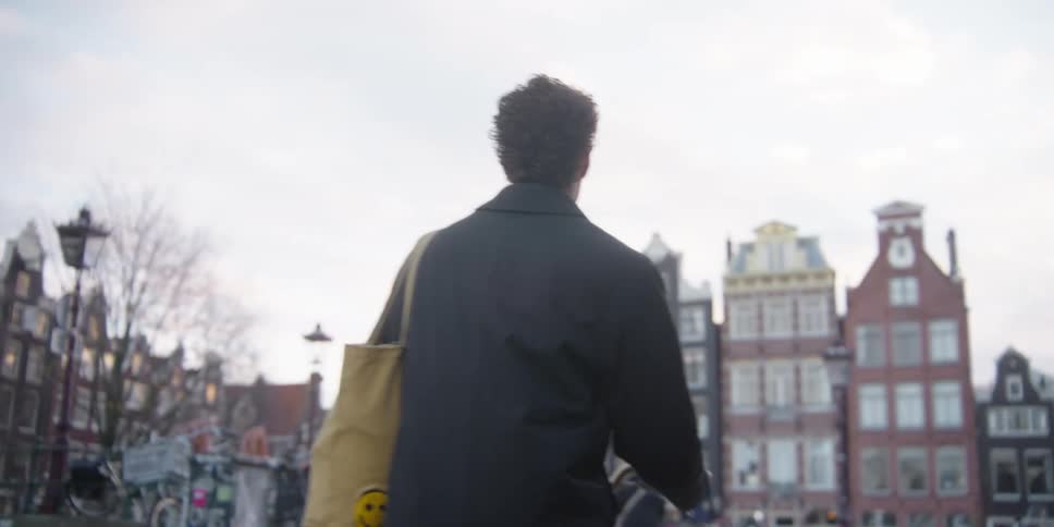 Man riding a bicycle on a city road at sunset