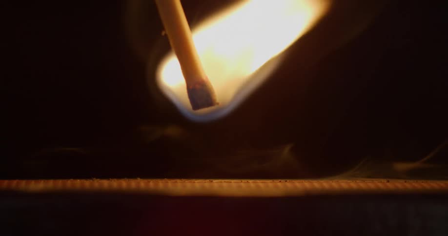 A match struck across a surface lights and then fades