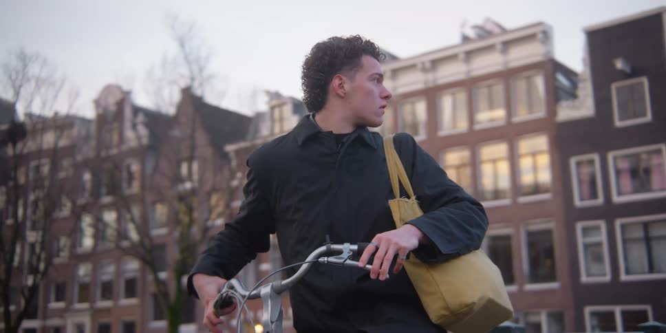 A man rides off on his bicycle at midday