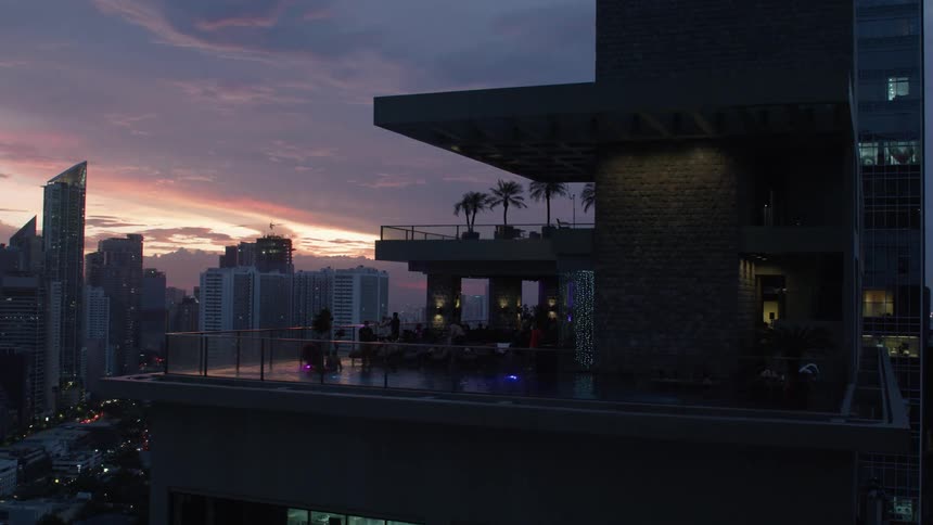 Panorama of a modern building with a swimming pool and a metropolis with its purple in the late afternoon