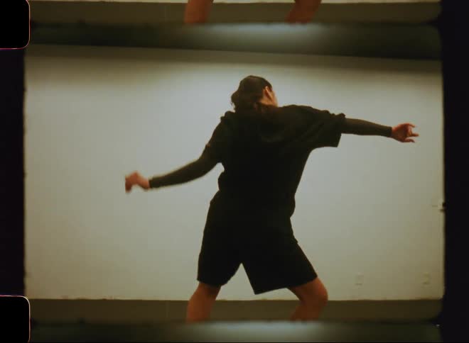 A teenage girl performs a frenzied dance in a room