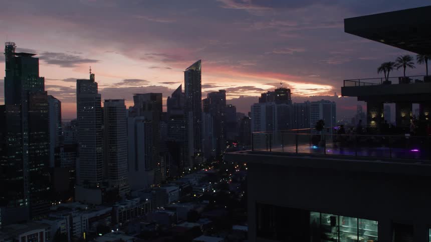 A scenic view of a city skyline and a rooftop terrace at sunset
