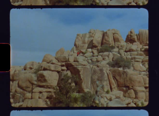 A person hiking on a rocky mountain during the day