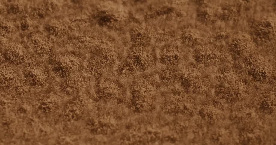 Extreme close up on uniform sand shaking and generating polka dots