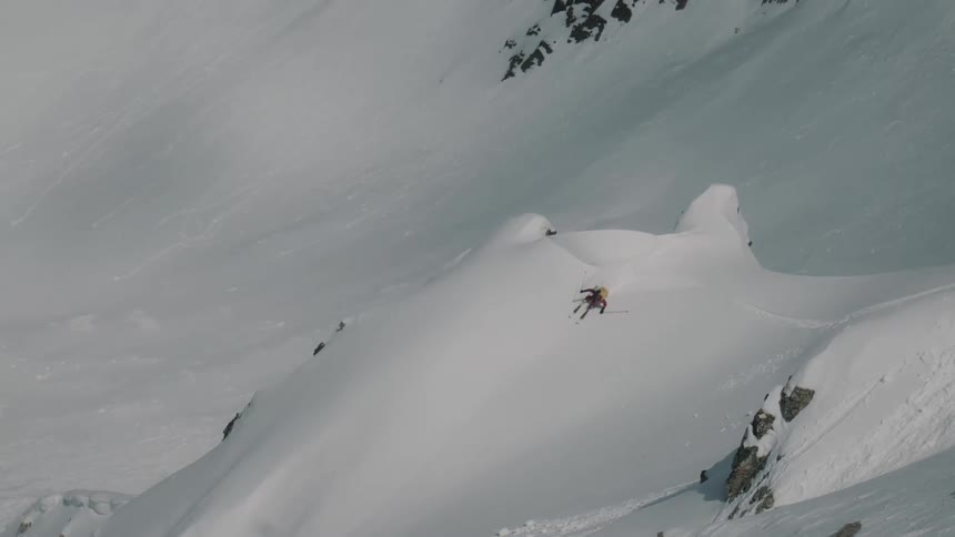 Skier making a powder turn in snowy mountains
