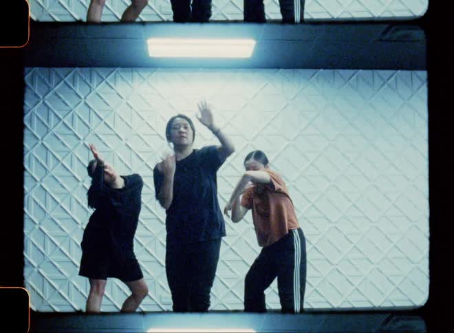 Three people inside a studio dancing together