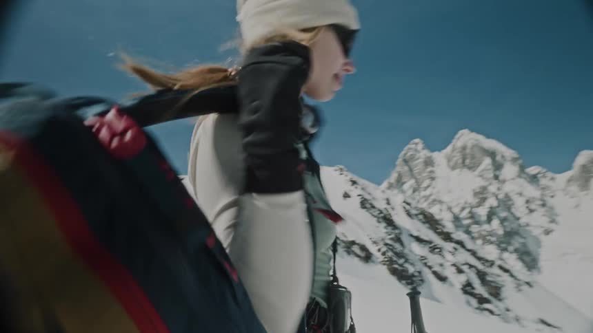 Lady drops her backpack on the ground to get ready for skiing