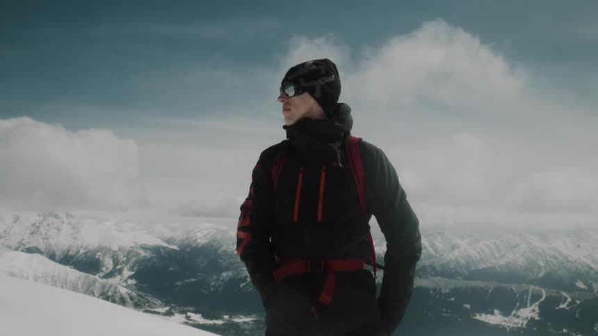 A man on top of a mountain admiring the landscape during winter