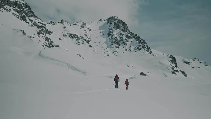 Two people skitouring with an equipment in a snowy mountains