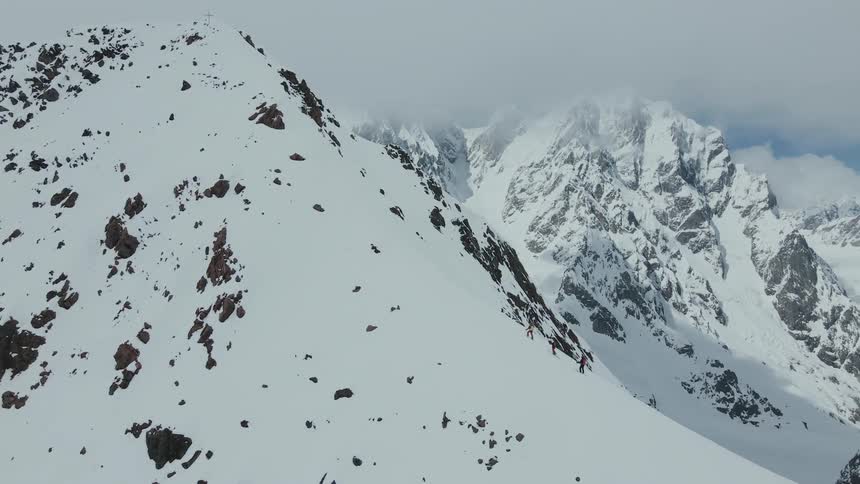 Riders skitouring a snow-covered mountain during midday