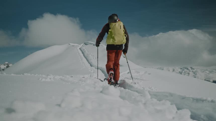 Person walking with ski equipment on a snowcovered mountain