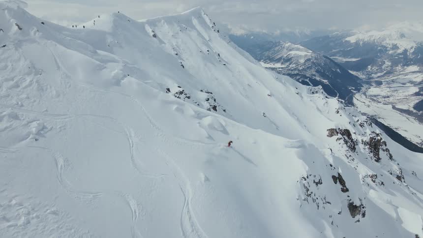 A skier riding down the snowy mountain