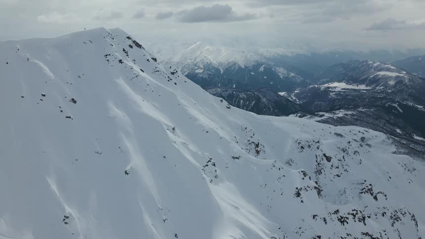 Aerial panorama of skier riding down a mountain