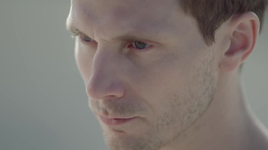 A man deep in thought and looking down raises his eyes