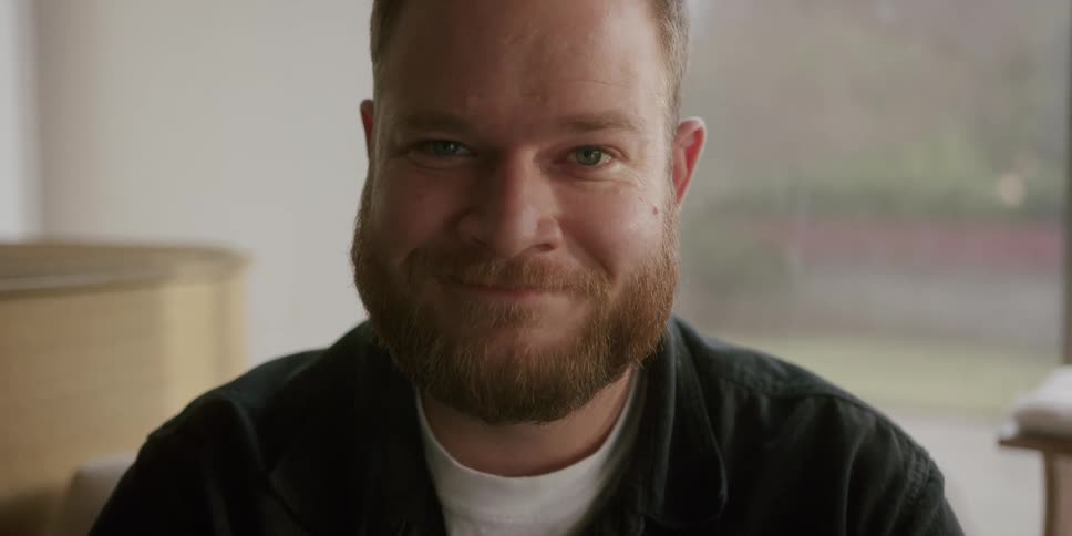 Portrait of a man with light eyes with a beard smiling
