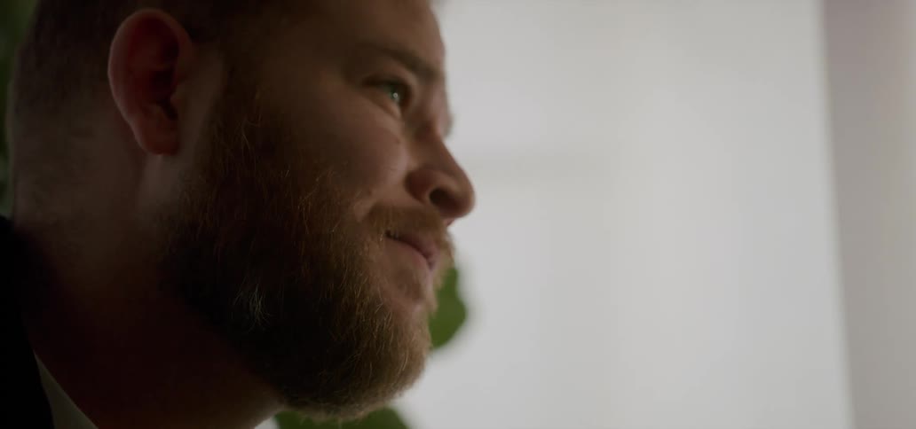 A sad man in a room looks into the distance