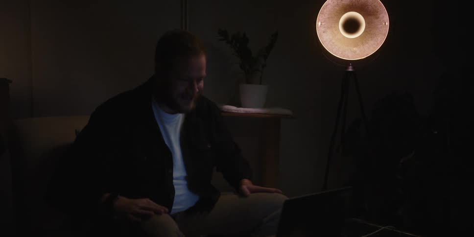 A man sitting in a room using a laptop