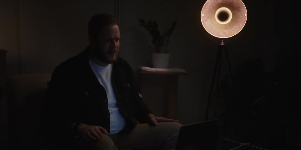 A man looking sad sitting in a room