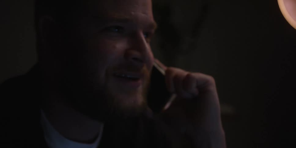 Close up of a bearded man talking on the phone at night