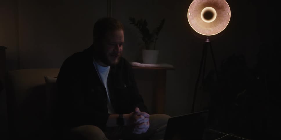 A man seems determined as he speaks to someone through a laptop