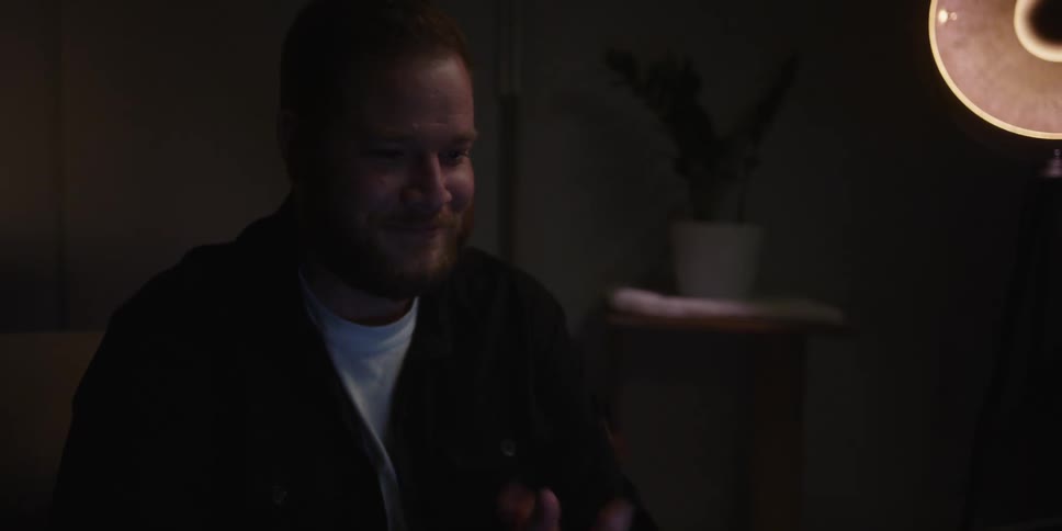 A man smiles and speaks to someone