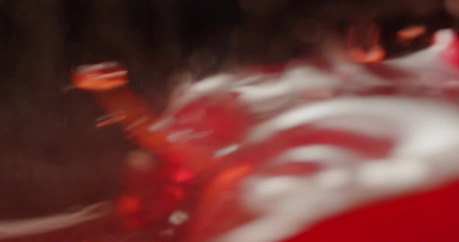 A pink liquid sloshes back and forth