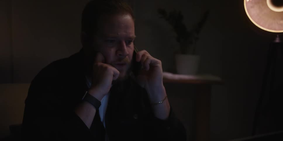 A man looks worried before picking up a phone and answering it