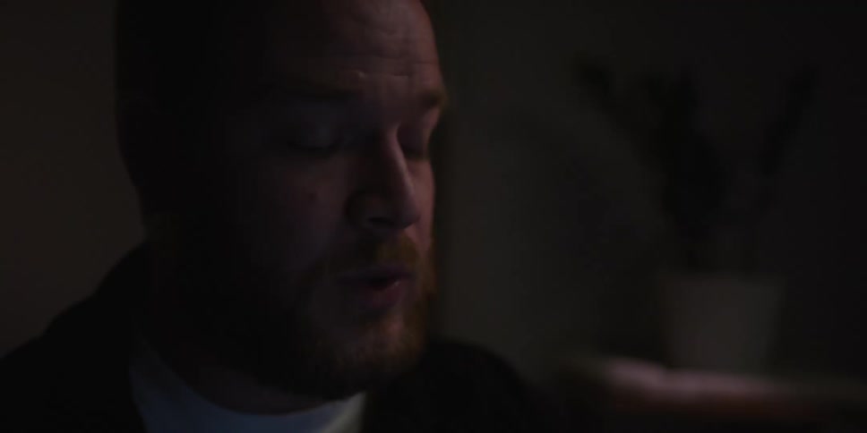 A man is talking in the dark room