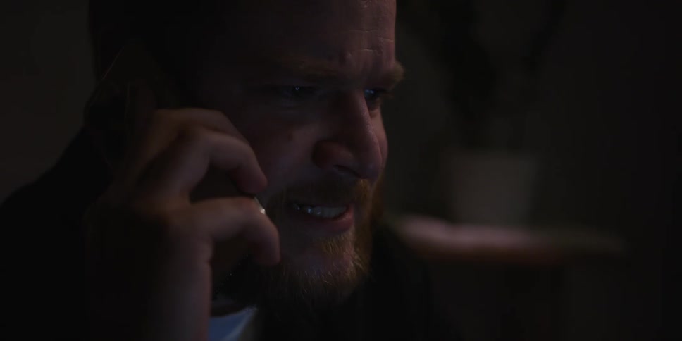 A man looks worried as he talks into a phone