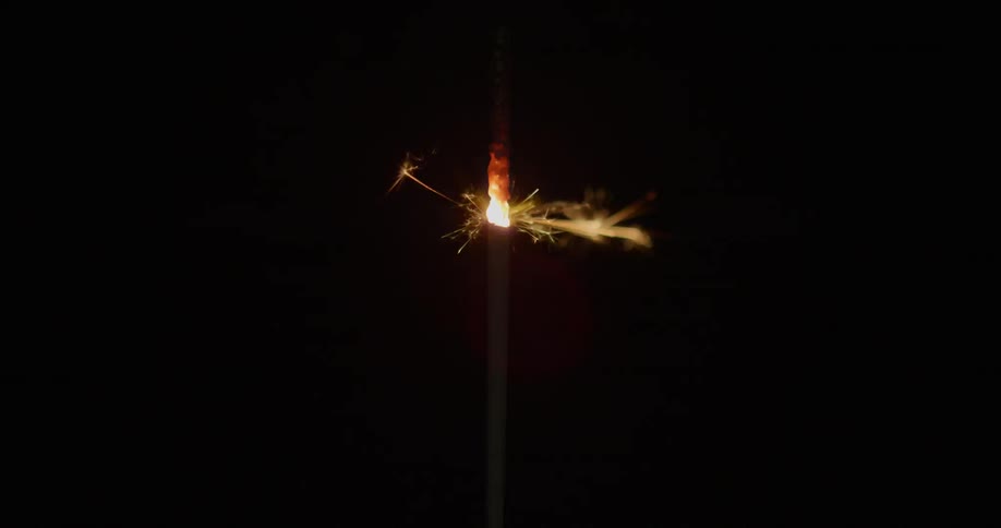 A sparkler burns at night