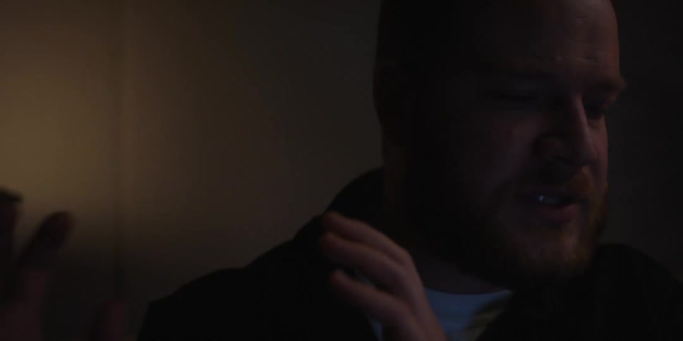 Portrait of a bearded man talking in a room with low lighting