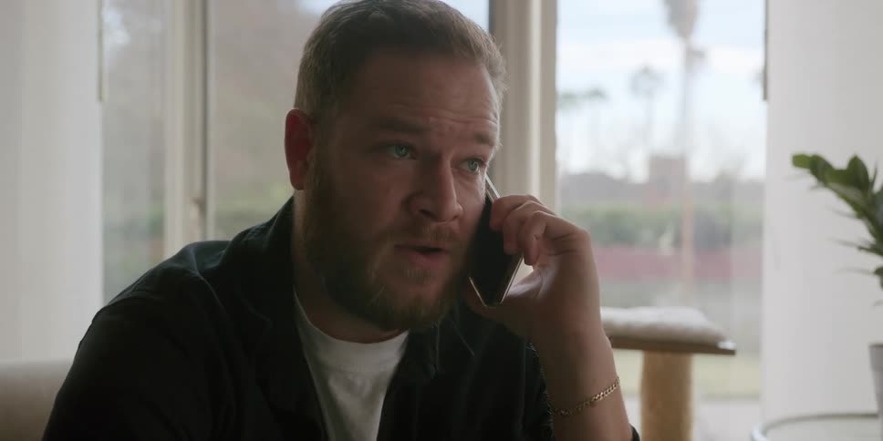 A man seems a bit bothered while speaking on a phone