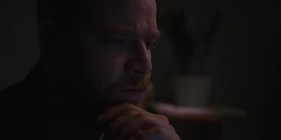 Portrait of a worried man drinking a cup of coffee in a dark room