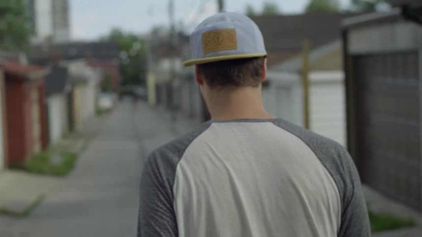 A man walks down a garage lined street
