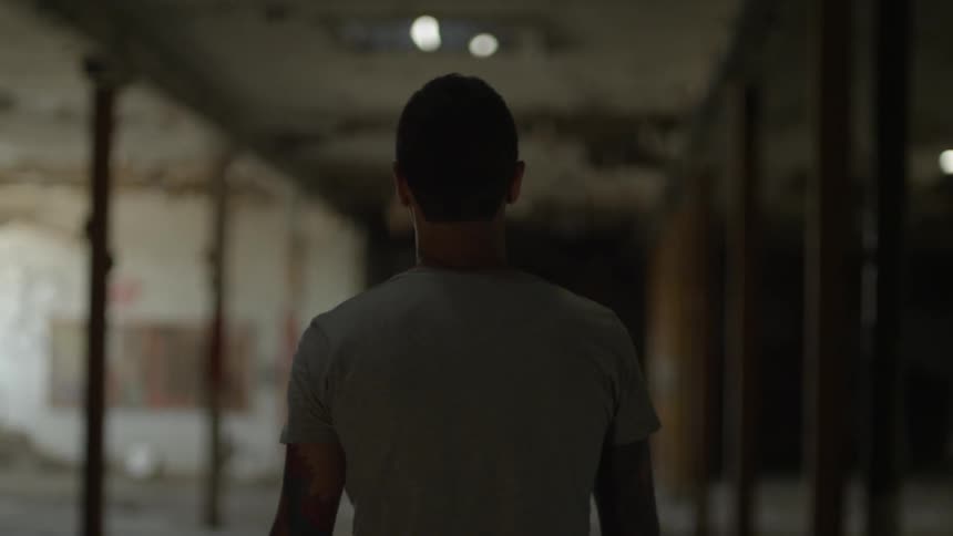 A man walks down a post lined corridor