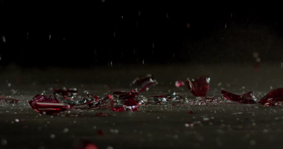 Red glass shatters on the ground