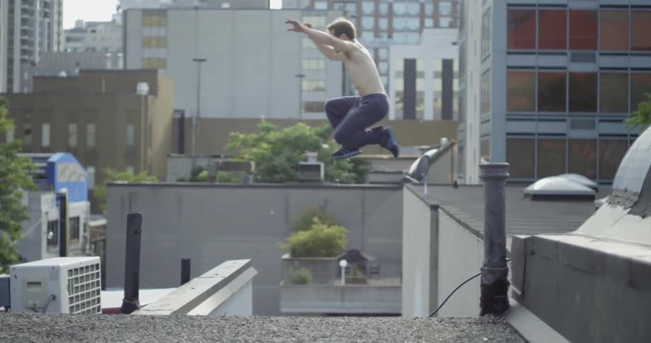 Man running and jumping from one building to another