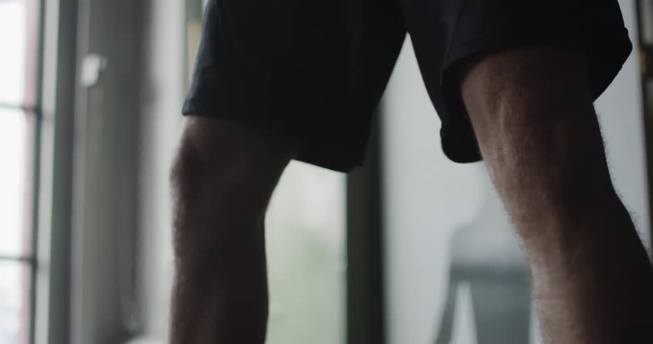 A white male lifts two kettlebells