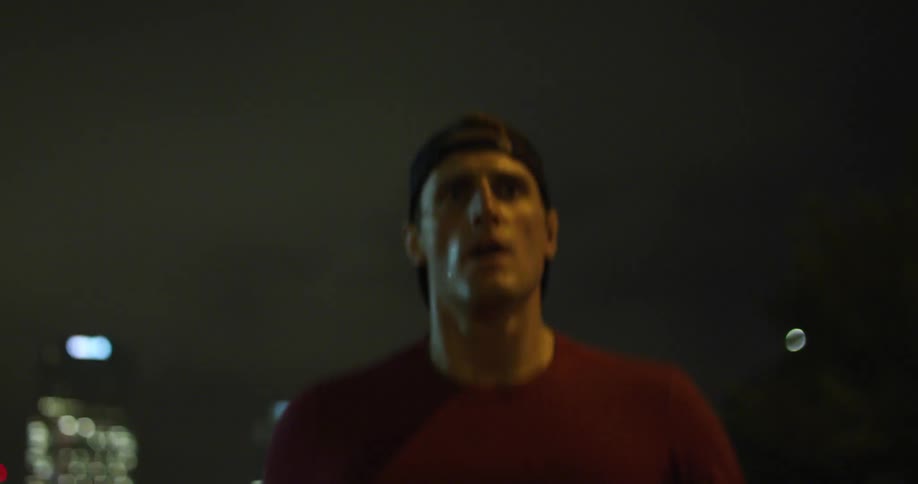 Portrait of a man running on the city streets at night
