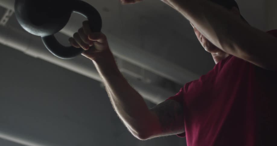 A white man lifts weights in a gym