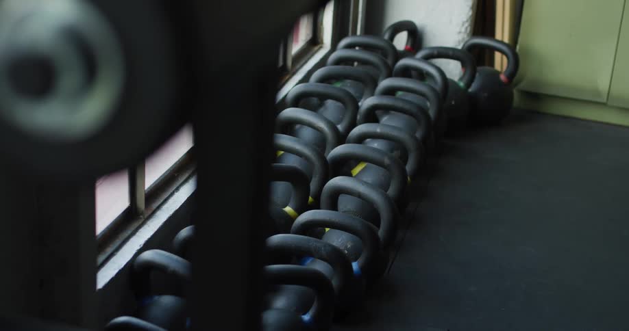 A row of kettlebell weights sit on a gym floor