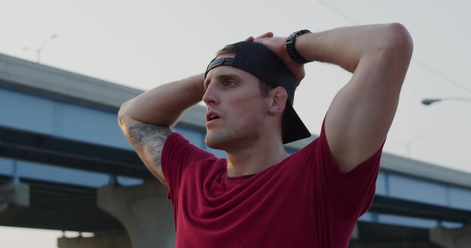 Portrait of a man putting his hands behind his head outdoors in the city
