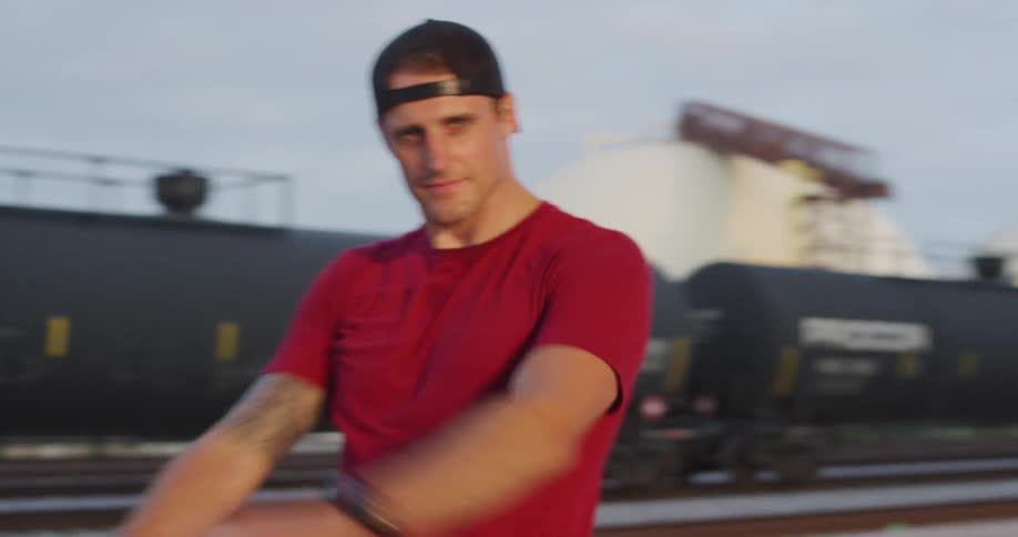 A man stretching his arms while standing under a bridge at daytime