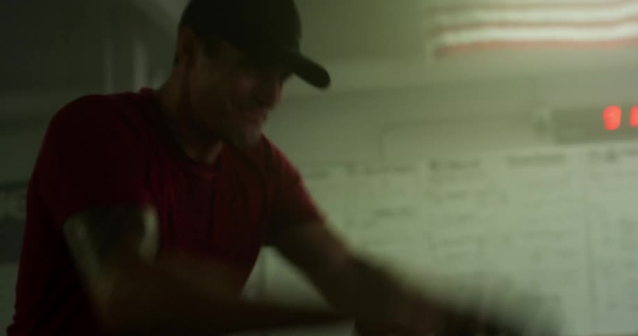 Concentrated and sweaty man hitting ropes inside a crossfit gym