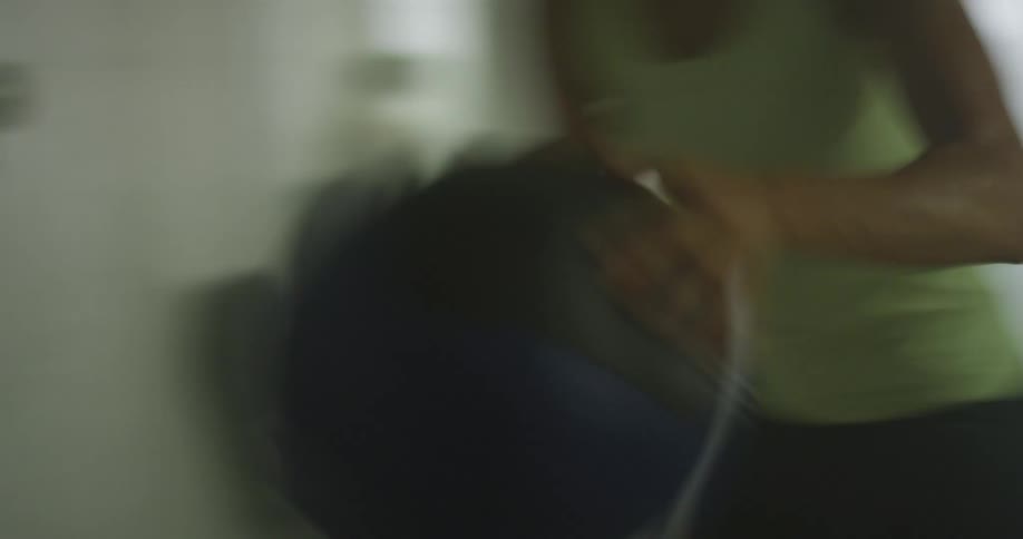 Concentrated woman throwing a weight ball against the wall