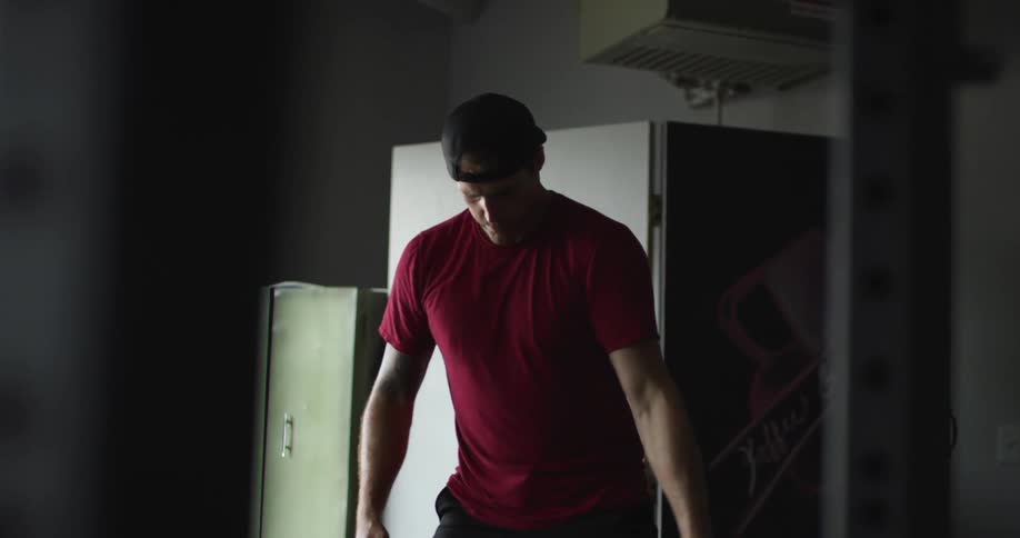 Man in a gym lifting weights with his arms