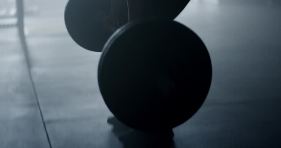 Strong muscular woman lifting weights at the gym