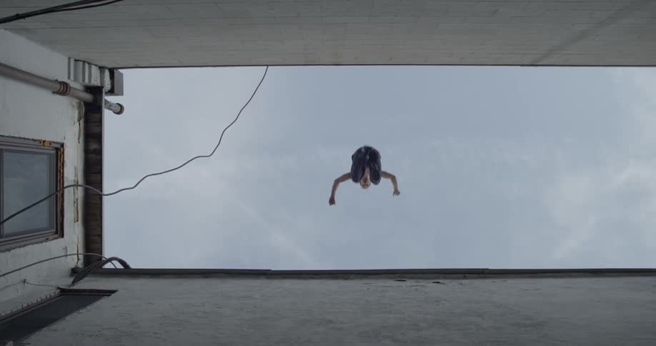 A man jumps from one rooftop to another