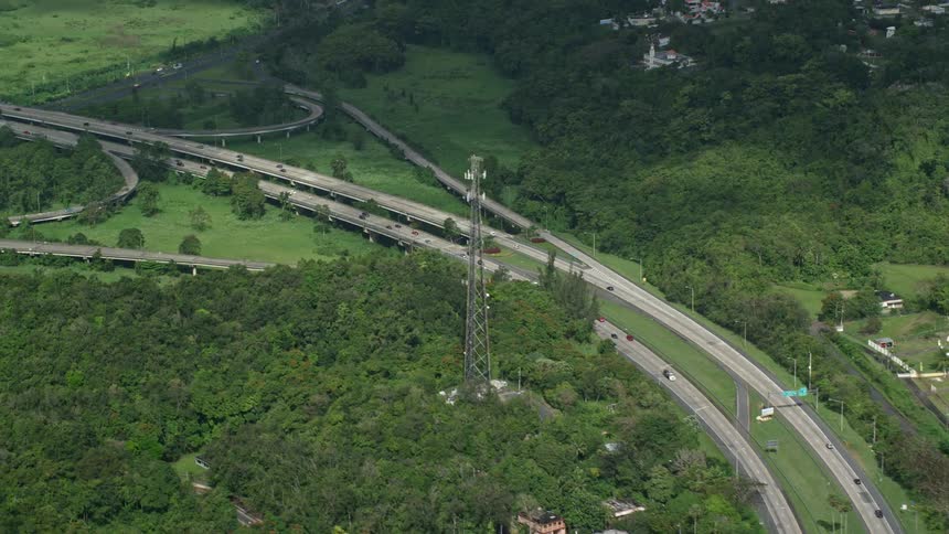 Aerial panorama of a highway in the middle of a forested area with vehicle traffic